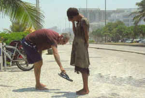 man giving his shoes to a homeless girl in Rio de Janeiro.