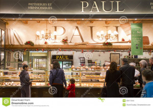 People buying bakery products from a Paul patisserie.
