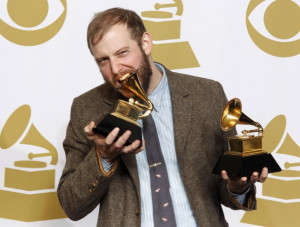 Singer Justin Vernon of Bon Iver bites one of his two Grammy Awards ...