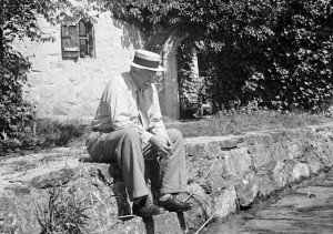 Psychiatrist Dr. Carl Jung pensively sitting on stone wall outside his ...