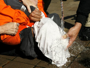 Demonstrator Maboud Ebrahimzadeh is held down during a simulation of ...