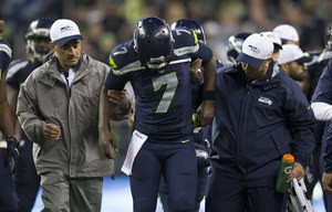 Seahawks quarterback Tarvaris Jackson is helped from the field in the ...