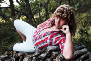 Funny picture of a YMCA hillbilly guy posing on a pile of logs