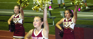 The JV cheer team cheers on the sidelines at a fall football game ...