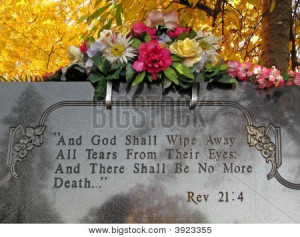 silk flowers on a cemetery grave tombstone revelations bible verse