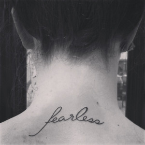 Fearless” quote tattoo on back of girls neck