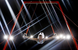 Image: Lights flare as Harry Owen of Wales performs on the rings ...