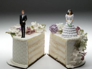 Bride and groom figurines standing on two separated slices of wedding ...
