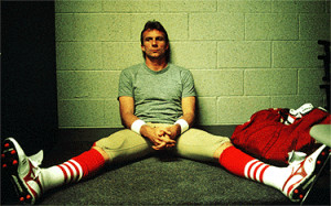 Joe Montana rests wearily against the locker room wall