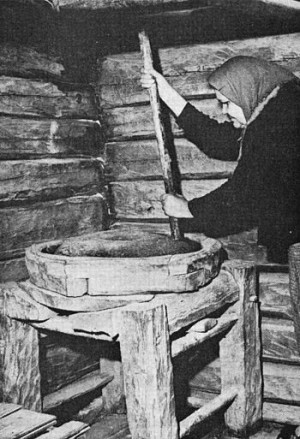 English: Woman grinding flower at a millstone in Finland in the early ...