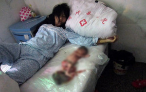 Chinese mother lying on a hospital bed with her aborted 7-month-old ...