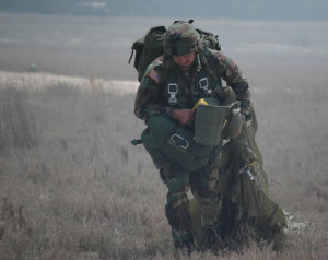 Sgt. Matthew Carey from 1st Ranger Battalion moves with his parachute ...