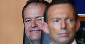 Bill Shorten sits behind Tony Abbott at an official event.