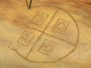 Iroh drew the symbols of the bending arts in the dirt.