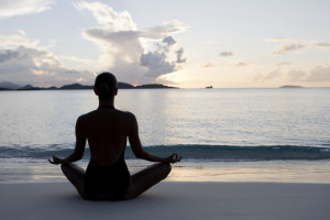 ... woman practicing yoga at the Caribbean beach during sunset or sunrise