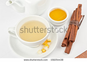 Cup of hot linden tea with cinnamon sticks, and honey - stock photo