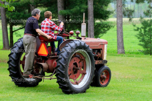 Grandfather and Grandson Driving a Vintage Tractor - Stock Image