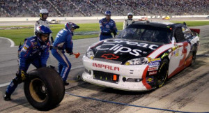 NASCAR vehicle and pit stop are shown. | AP Photo