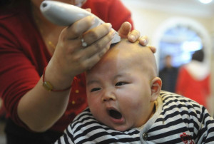 baby yawns while getting a haircut at a barbershop in China. Reuters