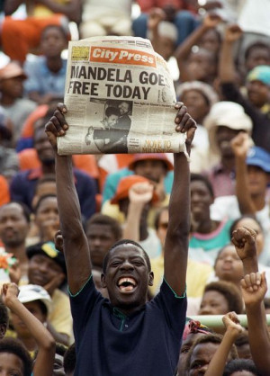 man holds up a newspaper as Nelson Mandela's release is celebrated ...