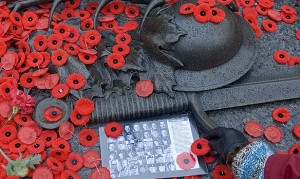 woman places a poppy at a makeshift memorial to Canadian soldiers ...