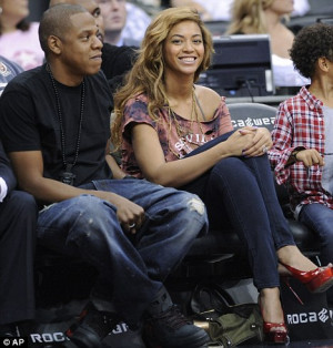 ... firmly covered at basketball game... as Jay-Z denies pregnancy rumours