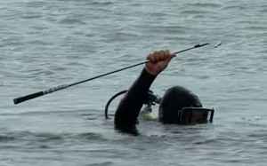 scuba diver holds Rory McIlroy's three-iron aloft after rescuing it ...