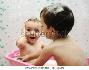 Adorable baby boy taking a bath with soap suds on hair - stock photo