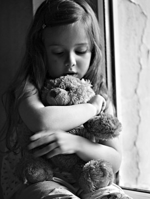 This little cute girl hugs her Teddy Bear.