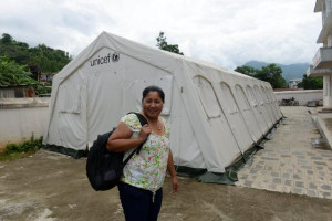Nepalese public health nurse Sanu Maiya Rana walks past a UNICEF tent ...