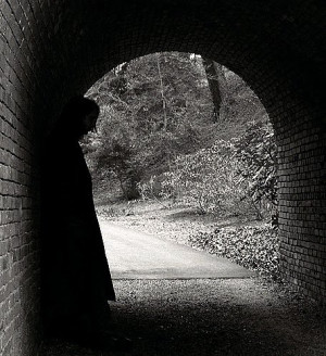 ... this picture shows a man hiding in the shadows of the dark tunnel