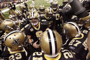... Saints quarterback Drew Brees leads the team huddle before every game