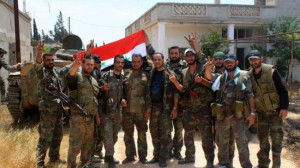 Syrian army soldiers pose for a photograph as they hold the Syrian ...