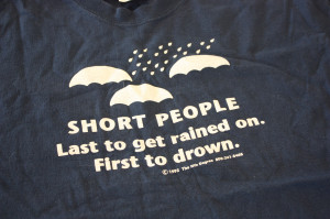 ... shirt says “short people…last to get rained on. First to drown
