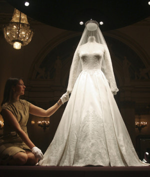Exhibition curator, Caroline de Guitaut, adjusts the wedding dress of ...