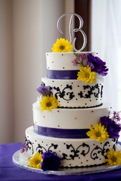 White wedding cake with black detail, accented with yellow and purple ...