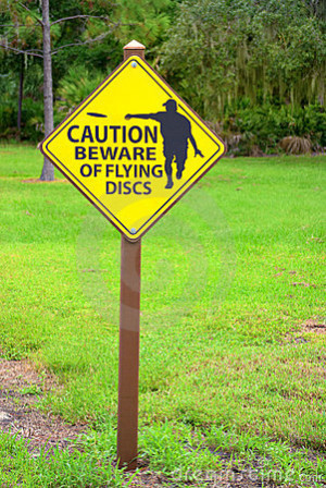 Flying discs caution sign at a disc golf course.