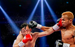 Pakistani children play in the rain under an umbrella in a slum on the