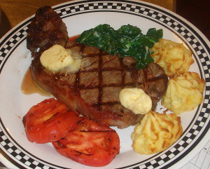 Grilled New York steak with roasted garlic compound butter, creamed ...