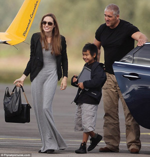 Lucky boy: Flanked by a burly bodyguard, Angelina Jolie took her ...