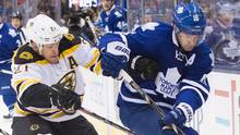 Toronto Maple Leafs' Clarke MacArthur battles for the puck with Boston ...