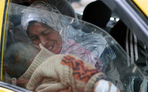 Syrian woman cries holding her injured son in a taxi as they arrive ...
