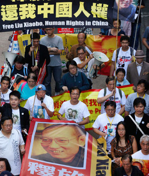 holding banners bearing photos of jailed Chinese dissident Liu Xiaobo ...