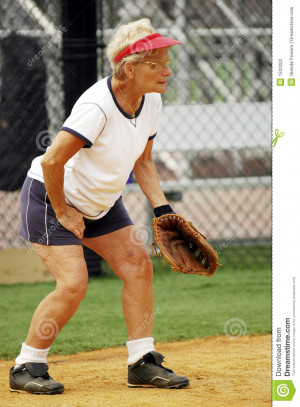 Senior woman playing catcher in softball game.