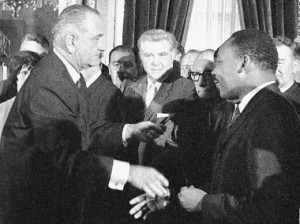 President Lyndon Johnson reaches to shake the hand of