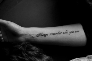 Always remember who you are” quote tattoo on girls arm