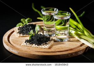 Vodka and black caviar on black background - stock photo