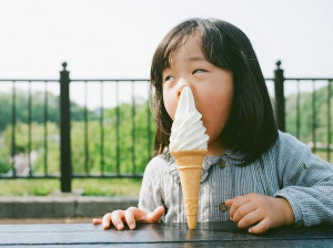 Funny girl putting ice cream in her nose