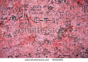 Grunge background of graffiti and sayings carved on a red wall