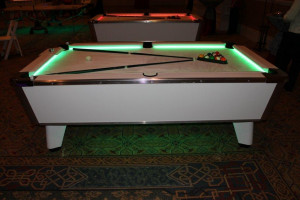 White finished billiard table with LED lighting washing the playing ...